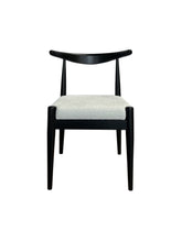 Japandi stoel van essenhout in diep zwart met witte bouclé stof, minimalistisch design geïnspireerd door Japanse en Scandinavische stijlen